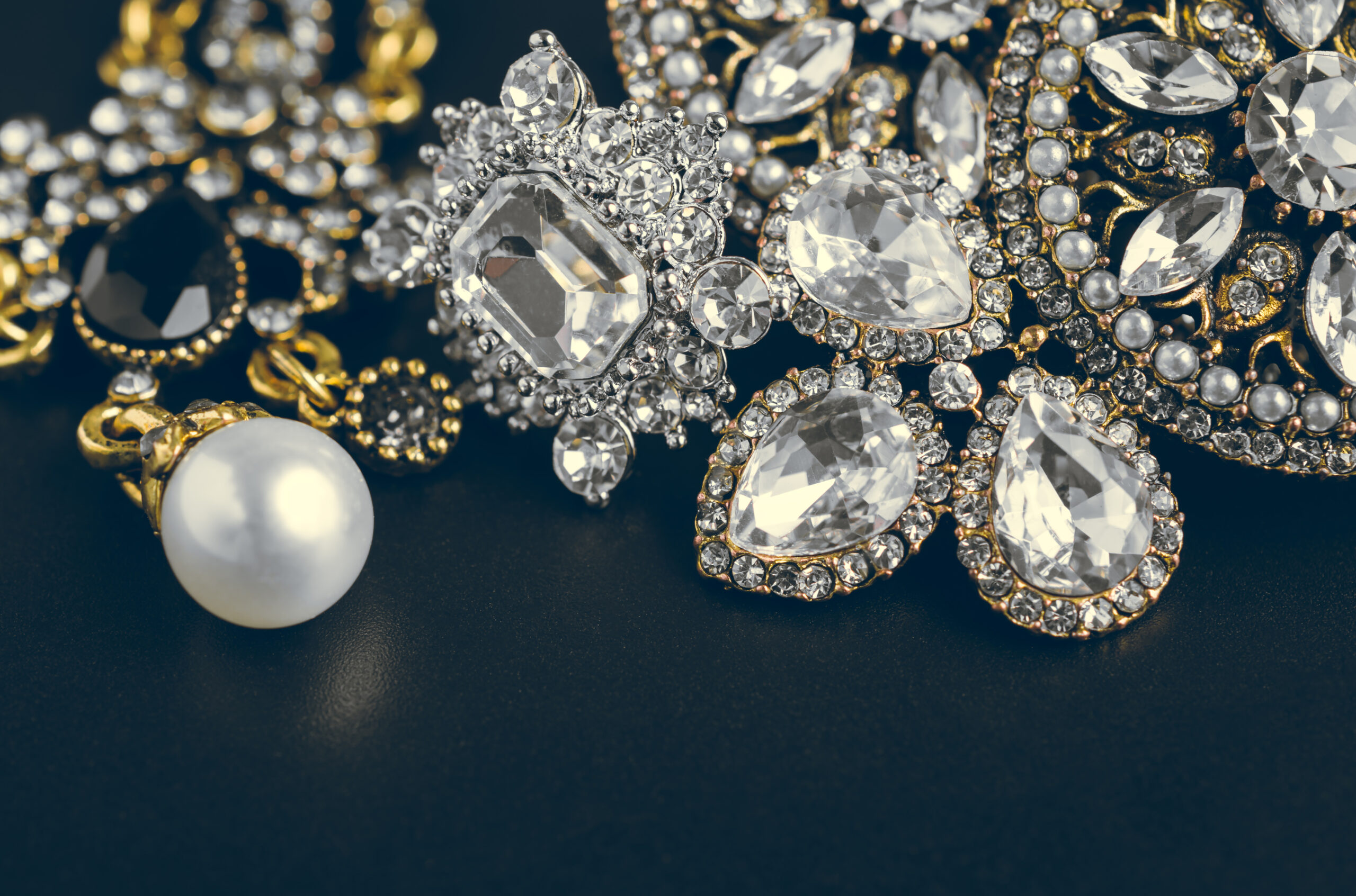 Pearl and diamond fine jewelry on dark fabric