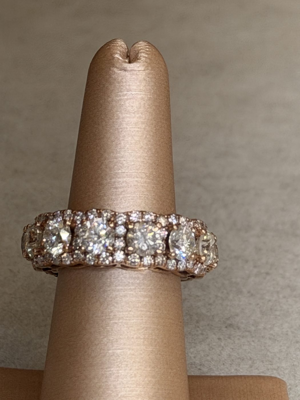 Rose gold diamond eternity band worn on a ring display finger