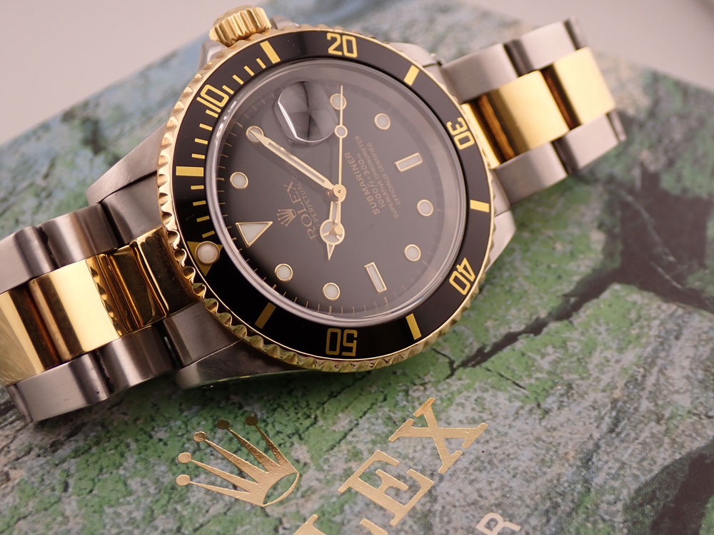 Luxury two-tone Rolex watch resting on green stone